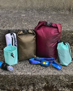 various items are lined up on the ground next to each other, including a backpack and water bottle