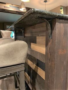 a wooden counter top sitting next to a mirror in a room with lights on it