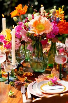 the table is set with colorful flowers and candles