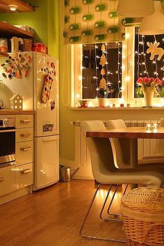 a kitchen filled with lots of furniture and lights on the window sill above it