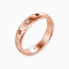 a rose gold wedding ring with three stones on the side and an arrow design in the middle