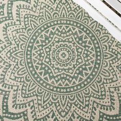 a green and white rug sitting on top of a wooden floor