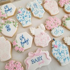 decorated baby cookies are displayed on a table