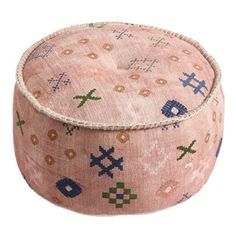 a pink and blue ottoman sitting on top of a white floor