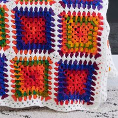 a crocheted granny blanket with multicolored squares on the front and back