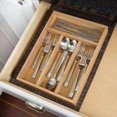 a wooden tray with utensils and spoons in it