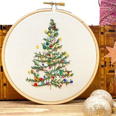 a cross stitch christmas tree is on the table