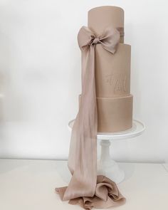 a three tiered cake with a bow on top