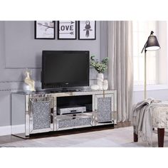 an entertainment center with mirrored doors and drawers