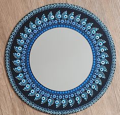 a blue and black plate sitting on top of a wooden table next to a mirror