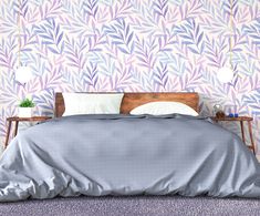 a bed sitting in front of a purple wall with leaves on it and a wooden headboard