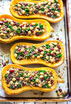 baked stuffed squash with cranberries and nuts on a baking sheet