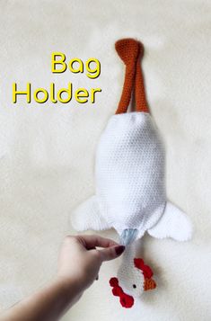 a person is holding a stuffed animal in the shape of a fish