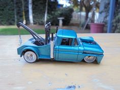 a blue toy truck with tools in the bed and on top of it's flatbed