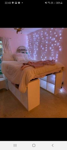 a bed with lights on the wall behind it