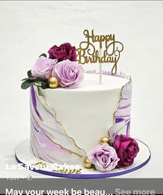 a birthday cake with purple flowers and a happy birthday sign