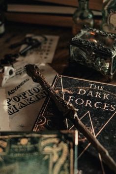 the dark forces book is laying on top of some other books and glass bottles in front of it