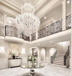 an elegant foyer with chandelier and marble floors