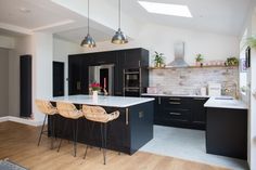 an open kitchen with black cabinets and white counter tops is seen in this image from the dining room