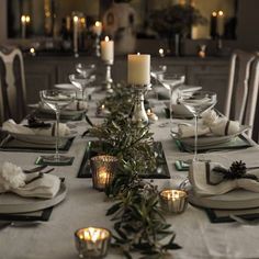 a table set with place settings and candles