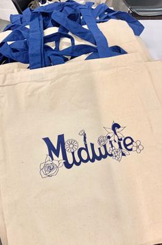 "Unique and Beautiful Midwife Tote Bag with flower accented design. Measuring 15\"W x 16\"H with 23\" handles." Nursing Wallpaper, Nurse Outfit Scrubs, Nurse Outfit, Merch Aesthetic, Nursing Clothes, Cotton Tote Bag, Cotton Totes