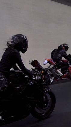 two motorcyclists are riding down the street on their motorcycles, one is wearing a helmet