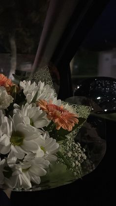 flowers are sitting in the center of a glass bowl on top of a car dash board