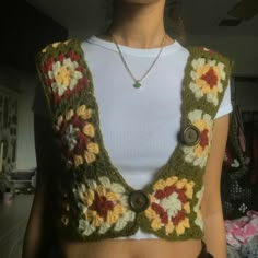 a woman wearing a crocheted vest with flowers on it