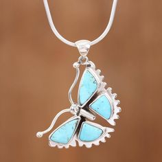 A beautiful butterfly soars on this pendant necklace handcrafted by Guillermo Arregui. Sweet blue reconstituted turquoise graces the a sterling silver body with its scalloped wings. Elegant Turquoise Butterfly Jewelry, Sterling Silver Butterfly Gemstone Necklace, Nickel-free Sterling Silver Butterfly Necklace, Nickel-free Sterling Silver Butterfly Pendant Necklace, Blue Butterfly Sterling Silver Jewelry, Silver Jewelry With Butterfly Charm, Sterling Silver Necklace With Butterfly Charm Round Pendant, Bohemian Butterfly Sterling Silver Necklace, Bohemian Sterling Silver Butterfly Necklace