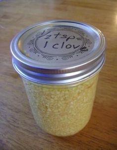 a glass jar filled with yellow liquid sitting on top of a wooden table