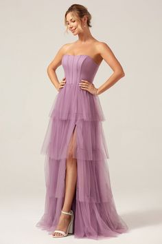 a woman in a strapless purple dress poses for the camera with her hands on her hips