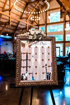 a wedding seating plan is displayed on a easel in the middle of a room