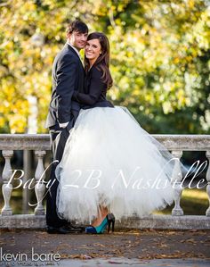 a bride and groom posing on a bench