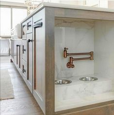 a kitchen with marble counter tops and stainless steel faucets on the wall, along with two sinks