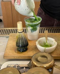 a person pouring green liquid into a cup