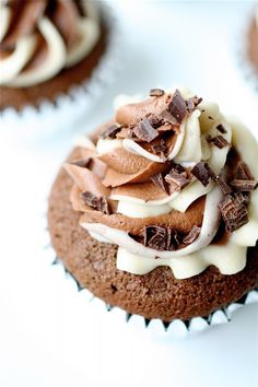 chocolate cupcakes topped with white frosting and sprinkles