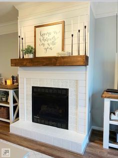 a living room with a fire place and white fireplace mantel in the middle of it