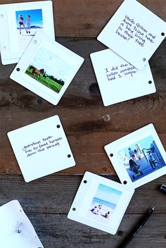 several pictures and pens on a wooden table with writing attached to the frames that have been placed in front of them