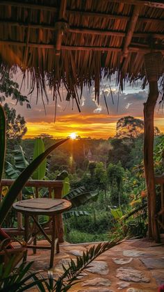 the sun is setting over some trees and greenery in front of a patio area