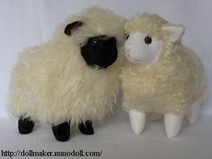 two stuffed sheep standing next to each other on a white background, one black and the other white