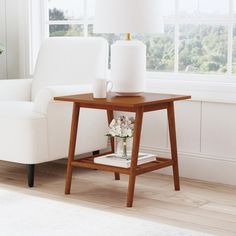 a living room with a white chair and table in front of a large window on the wall