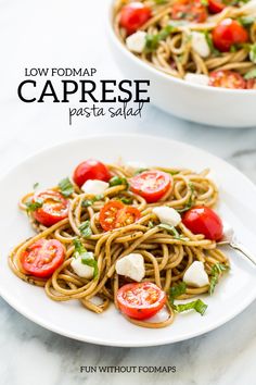 pasta with tomatoes, mozzarella and parmesan cheese on a white plate