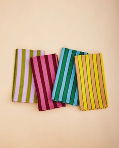 four different colored striped napkins sitting next to each other