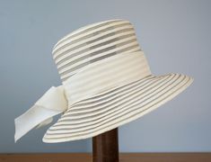 "DESCRIPTION * vintage hat from 1950s-1960s * Bucket hat design: tall flat crown, wide downturned brim * made of beige synthetic straw, swirled pattern of crinoline and polybraid capeline * the hatband is wrapped with thick velvet ribbon and formed two tails on the side * no tag CONDITION * hat is in good condition and shows signs of normal use but there are a few stains on the ribbon and a few natural yellowing spot on capeline braid which may look like some soiling but they are not. Please see 1950s Hats For Women, Vintage Beige Sun Hat For Summer, 1950s Sun Hat, Vintage Cream Brimmed Sun Hat, Beige Vintage Hats For Vintage Events, 1950s Hats, Vintage Straw Hat, Vintage Cream Wide-brim Straw Hat, Straw Bucket Hat