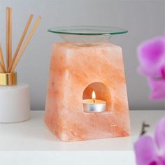 a candle is lit inside of a pink rock