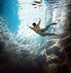 a man swimming under water in the ocean