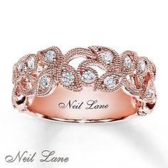 a rose gold ring with diamonds on the side and words next came written in white lettering