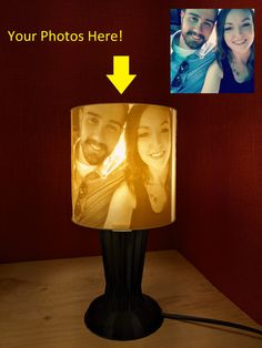 a lamp that is on top of a table next to a couple's photo