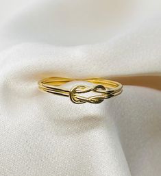 This simple and timeless look is perfect for any style. Infinity Knot rings are classy and can be stacked with many styles. This Infinity Knot ring is gold plated in 14 kt Italian Gold. Simple and dainty this ring will make a perfect gift for any jewelry lover!   FEATURES: * genuine 14 kt gold plating  * unique artisan design * free gift wrap * free international shipping SIZE: Standard size for all rings is  7 US. This size fits most adults but all of our jewelry can be changed. Please select c Elegant Gold Infinity Stackable Rings, Adjustable Infinity Ring For Formal Occasions, Classic Adjustable Infinity Stackable Rings, Classic Infinity Rings As A Gift, Classic Infinity Rings As Gift, Dainty Adjustable Ring For Formal Occasions, Classic Infinity Ring As A Gift, Classic Infinity Ring As Gift, Elegant Adjustable Infinity Stackable Rings