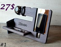 a cell phone and watch on a wooden stand with the name steven written on it